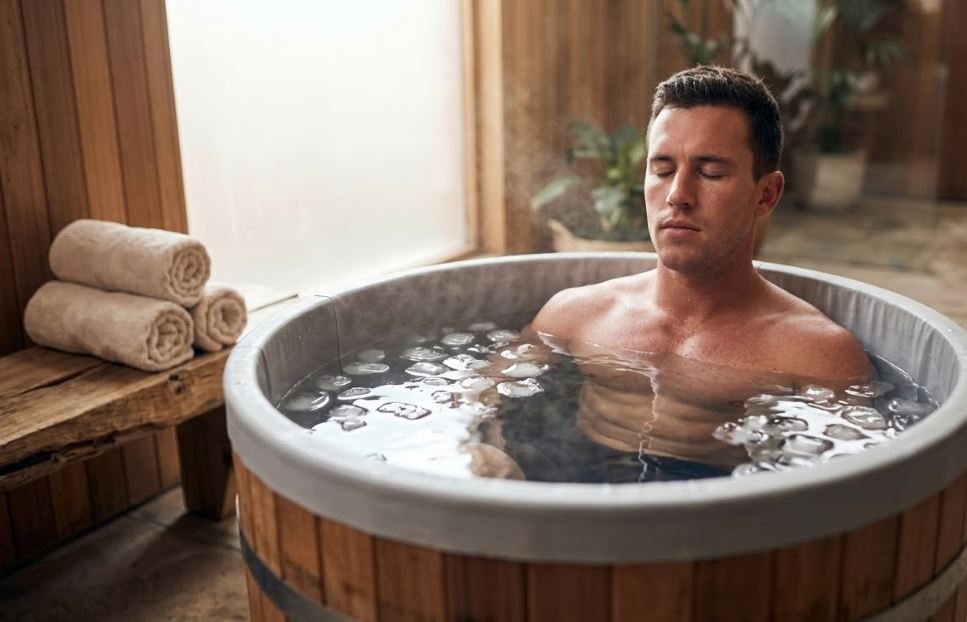 Sportif dans un bain de glace pour récupération musculaire après effort
