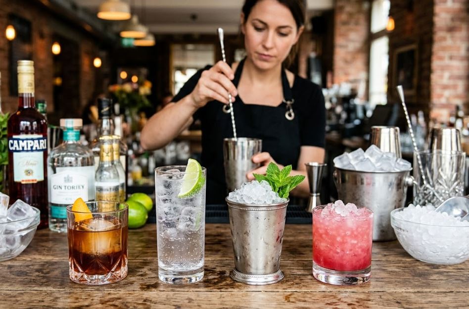 Différents cocktails servis avec glaçons cubes et glace pilée sur un comptoir de bar