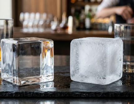 Comparaison entre un glaçon transparent et un glaçon opaque sur un comptoir